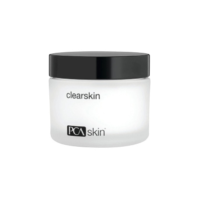 A close-up of a clear skin cream jar, showcasing its smooth texture and vibrant packaging against a neutral background.