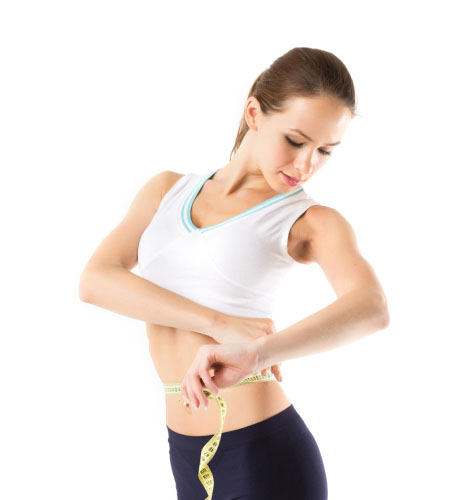 A woman measuring her waist with a tape measure, focusing on her health and fitness goals.