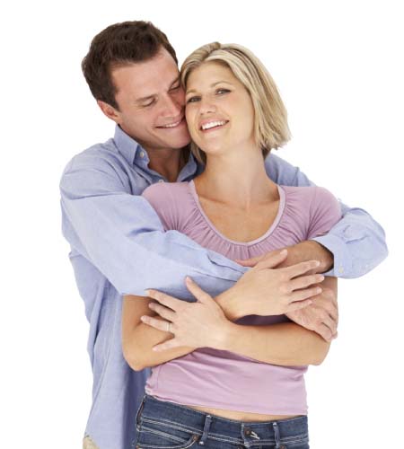 A man and woman embrace each other warmly against a clean white background, symbolizing love and connection.