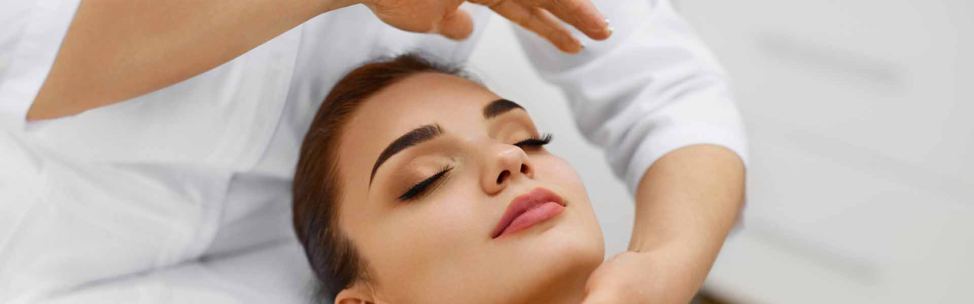 A woman enjoys a relaxing facial massage at a serene spa, surrounded by calming decor and soft lighting.