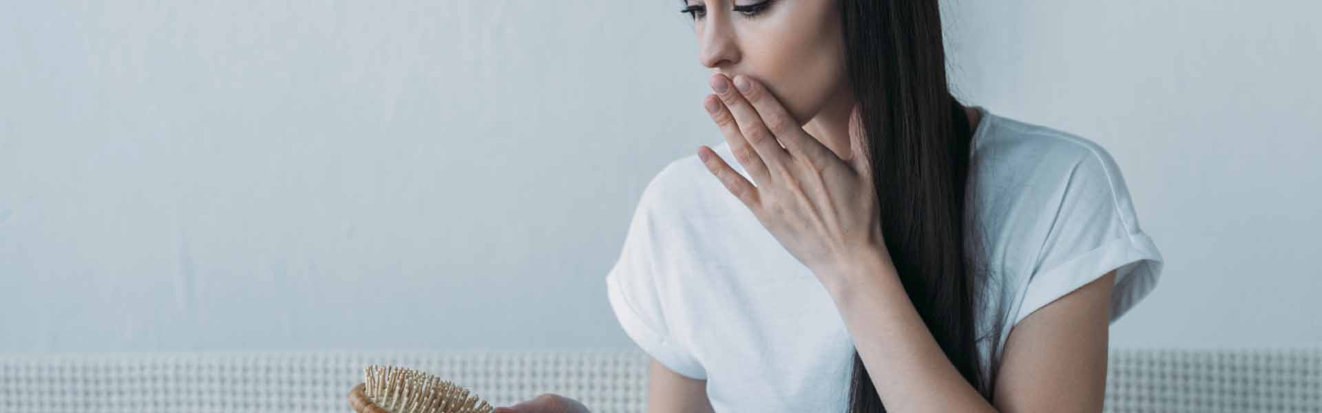 A woman sitting on a couch savors a donut, embodying a cozy and leisurely moment of enjoyment.